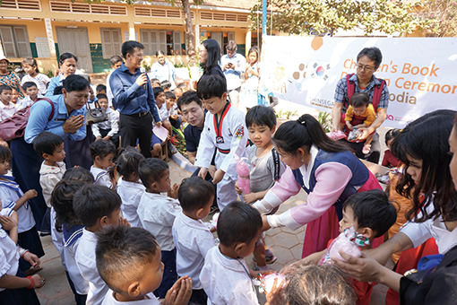 캄보디아 초등학생들에게 동화책을 나눠주는 행사 모습 이미지